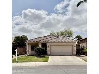 Charming single-story home features a tile roof, two-car garage, well-maintained lawn, and desert landscaping at 2865 E Cathy Dr, Gilbert, AZ 85296