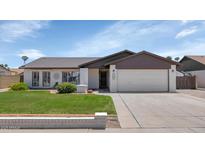 Charming single-story home features a well-maintained lawn, brick accents, and a two-car garage at 7331 W Aster Dr, Peoria, AZ 85381