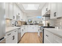 Modern kitchen with white shaker cabinets, quartz countertops and stainless steel appliances at 7359 E Valley View Rd, Scottsdale, AZ 85250