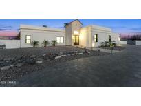 Elegant exterior view of a modern home with a well-manicured stone front yard and a paved driveway at 7860 E Davenport Dr, Scottsdale, AZ 85260
