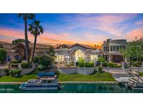 Stunning waterfront home with lush landscaping, private dock, and sunset views at 10120 E Topaz Dr, Scottsdale, AZ 85258