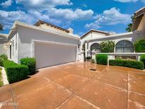 Beautiful home featuring a two-car garage, decorative plants, and a driveway at 10120 E Topaz Dr, Scottsdale, AZ 85258