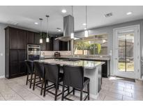 Modern kitchen boasts granite counters, stainless steel appliances, and a large island with bar stool seating at 10129 E Ampere Ave, Mesa, AZ 85212