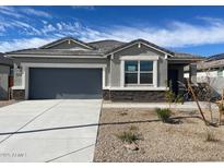 New single-story home with gray siding, two-car garage, and desert landscaping at 1144 Se Mullberry St, Florence, AZ 85132