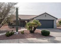 Single-story home with gray exterior, terracotta roof, and desert landscaping at 16043 W Copper Crest Ln, Surprise, AZ 85374