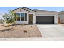 New construction home with a two-car garage and desert landscaping at 17735 W Mission Ln, Waddell, AZ 85355