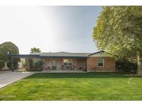 Brick ranch house with covered patio, driveway, and well-manicured lawn at 2111 W Mulberry Dr, Phoenix, AZ 85015