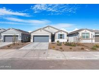 Charming single-story home featuring a gray stucco exterior, gray garage door, and lovely desert landscaping at 2530 W Sable Ave, Apache Junction, AZ 85120