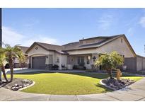 Charming single-story home featuring a well-manicured lawn and a desert-friendly landscape with healthy palm trees at 8171 W Beaubien Dr, Peoria, AZ 85382