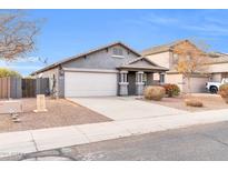 Single-story house with gray exterior, attached garage, and well-maintained landscaping at 11004 N 154Th Ln, Surprise, AZ 85379