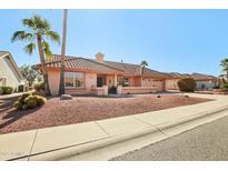 Single-story home with tile roof, desert landscaping, and a two-car garage at 13917 W Pavillion Dr, Sun City West, AZ 85375