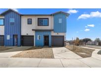 Two-story townhome with modern blue and white exterior, two-car garage, and desert landscaping at 7511 S 75Th Dr, Laveen, AZ 85339