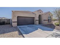 Inviting single-story home featuring a two-car garage, neutral color palette, and tile roof, perfect for modern living at 1203 E Judi St, Casa Grande, AZ 85122