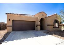 Tan house with brown garage door and arched entryway at 1203 E Judi St, Casa Grande, AZ 85122