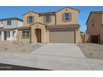 Two-story home featuring an attached two car garage, tan exterior, and a front yard at 24224 W Agora Ln, Buckeye, AZ 85326