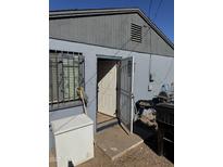 Rear home exterior view showing access door and small yard space at 2503 E Southgate Ave, Phoenix, AZ 85040