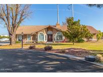 Charming single-story home with a clay tile roof, arched windows, and a well-maintained front yard at 2702 E Vaughn Ave, Gilbert, AZ 85234