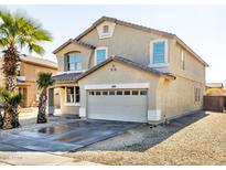 Two-story house with tan exterior, two-car garage, and desert landscaping at 3307 W Leodra Ln, Phoenix, AZ 85041