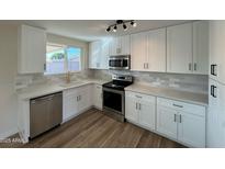 Remodeled kitchen features white cabinets, stainless steel appliances, and quartz countertops at 5313 W Osborn Rd, Phoenix, AZ 85031