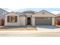 Charming single-story home with a tile roof, stucco finish and a two-car garage at 7163 W Oberlin Way, Peoria, AZ 85383