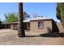Tan stucco house with carport and mature palm tree in front yard at 2010 N 37Th Pl, Phoenix, AZ 85008