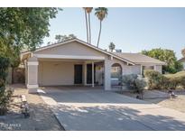 Charming single-story home with a large driveway, carport, and desert landscaping at 4215 W Griswold Rd, Phoenix, AZ 85051