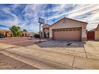 Tan house with a two-car garage and basketball hoop at 5003 W Davis Rd, Glendale, AZ 85306