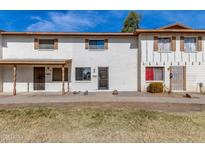 White stucco townhome with a covered entryway and small front yard at 7117 W Wolf St, Phoenix, AZ 85033