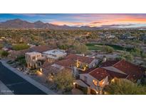 Stunning sunset aerial view of an estate with a red tile roof and mountain views at 8141 E Wingspan Way, Scottsdale, AZ 85255