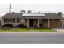 Charming home with solar panels, lawn, and covered front porch at 3341 W Windrose Dr, Phoenix, AZ 85029