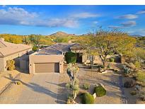 Beautiful single-story home featuring a spacious garage and desert landscaping, nestled against a scenic mountain backdrop at 33809 N 67Th St, Scottsdale, AZ 85266
