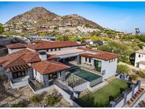 Luxury home featuring a pool, well-manicured lawn, and a stunning mountain view backdrop at 6825 N 39Th Pl, Paradise Valley, AZ 85253