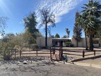 House exterior showcasing a charming ranch-style home with mature landscaping and a wooden bridge at 7043 E Ann Way, Scottsdale, AZ 85254