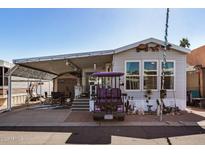 Mobile home exterior with covered carport and golf cart at 8700 E University Dr # 737, Mesa, AZ 85207