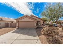 Tan house with a two-car garage and landscaping at 11465 W Virginia Ave, Avondale, AZ 85392