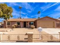 Tan house with a two-car garage and a landscaped front yard at 14409 N 34Th Way, Phoenix, AZ 85032