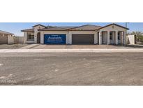 Attractive single-story home featuring a two-car garage, desert landscaping, and a welcoming entrance at 17399 W Whispering Wind Dr, Surprise, AZ 85387