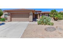 Single-story home with two-car garage and desert landscaping at 20876 N Canyon Whisper Dr, Surprise, AZ 85387