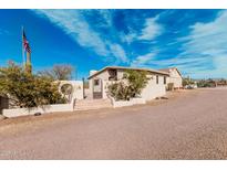 Charming home featuring desert landscaping, an American flag, and a beautiful gated entrance at 50031 N 27Th Ave, New River, AZ 85087