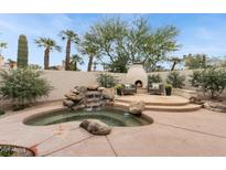 Gorgeous backyard with a rock waterfall feature, in-ground spa, and outdoor fireplace at 7705 E Doubletree Ranch Rd # 56, Scottsdale, AZ 85258