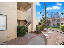 Exterior view of condo building with walkway and landscaping at 9275 E Mission Ln # 207, Scottsdale, AZ 85258