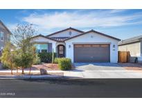 Charming single-story home featuring a two car garage, desert landscaping, and tile roof at 19920 N Wilford Ave, Maricopa, AZ 85138