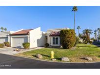 Exterior view of a charming condo with a two-car garage and desert landscaping at 663 S Saguaro Way, Mesa, AZ 85208