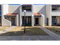Front view of a charming stucco townhome with a well-maintained lawn at 8434 N 54Th Dr, Glendale, AZ 85302