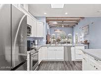 Bright kitchen with white cabinets, stainless steel appliances, and open to the living space at 10050 E Mountainview Lake Dr # 39, Scottsdale, AZ 85258