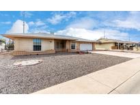 Charming single-story home with a brick facade, attached garage, and low-maintenance desert landscaping at 10437 W Caron Dr, Sun City, AZ 85351