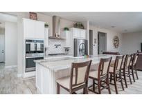 Spacious kitchen with island, stainless steel appliances, and white cabinetry at 18242 W Colter St, Litchfield Park, AZ 85340