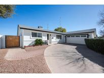 Charming single-story home featuring a well-manicured lawn and a spacious driveway leading to an attached two-car garage at 2113 N 66Th St, Scottsdale, AZ 85257