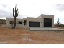 Contemporary exterior elevation showcasing a stucco finish and a black garage door at 431 W Rough Rider Rd, New River, AZ 85087