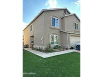 Two-story home featuring a neutral color scheme, attached garage, and a well-maintained artificial lawn at 5131 W Fairview St, Chandler, AZ 85226